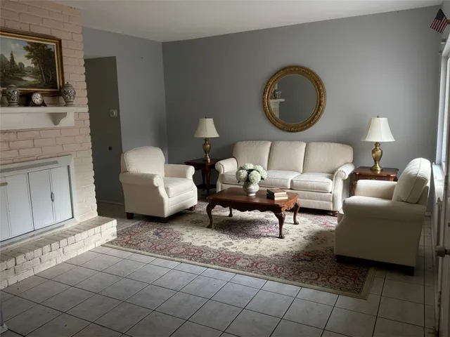 a living room with furniture a mirror and a flat screen tv