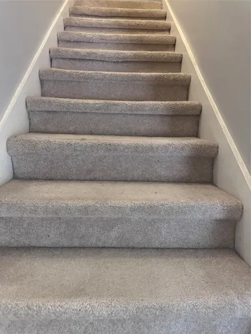 a living room with a couches and stairs