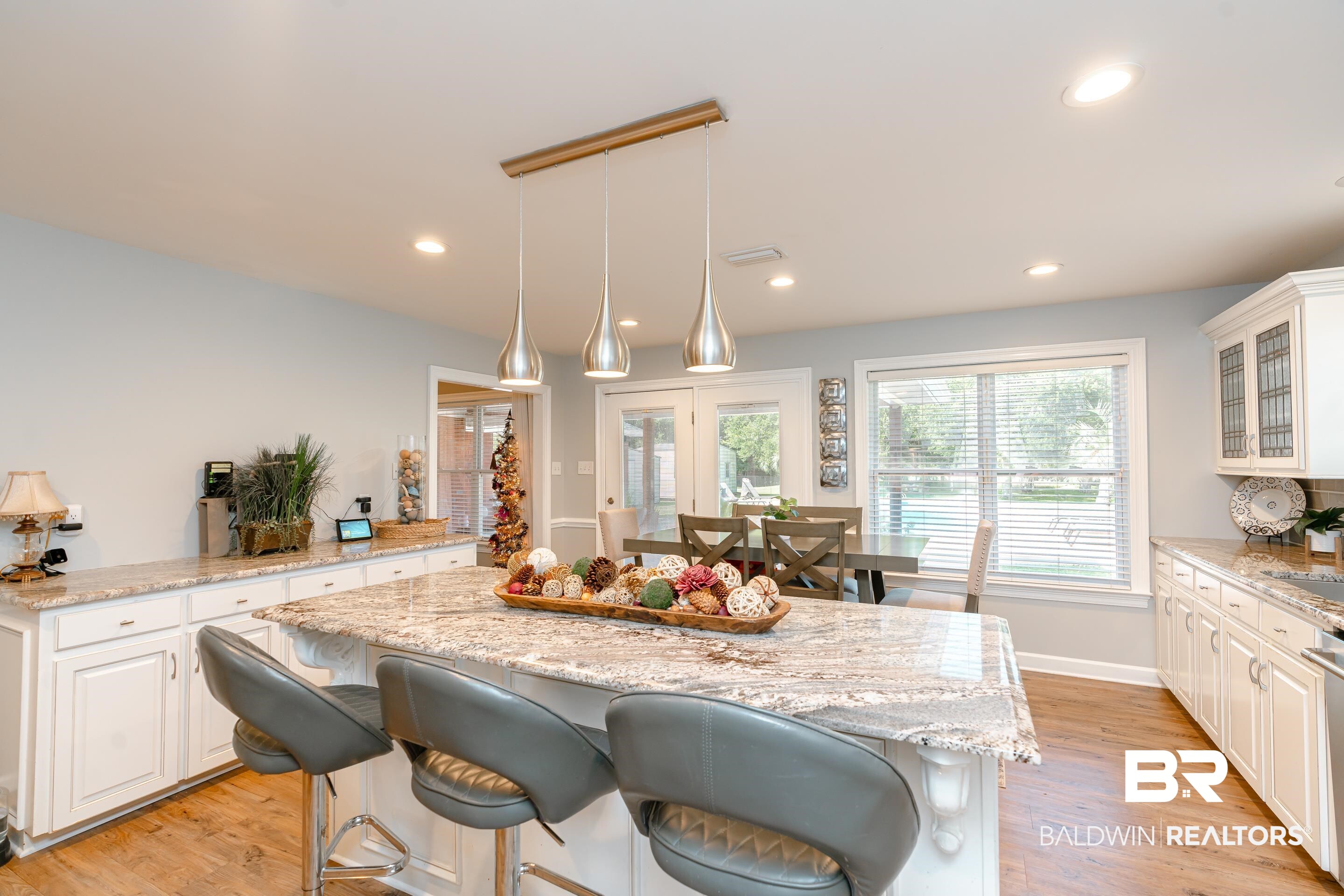9477 Deerfield Drive Irvington, AL 36544 - Photo 10 of 58 Kitchen with pendant lighting, white cabinets, light hardwood / wood-style floors, light stone counters, and a center island