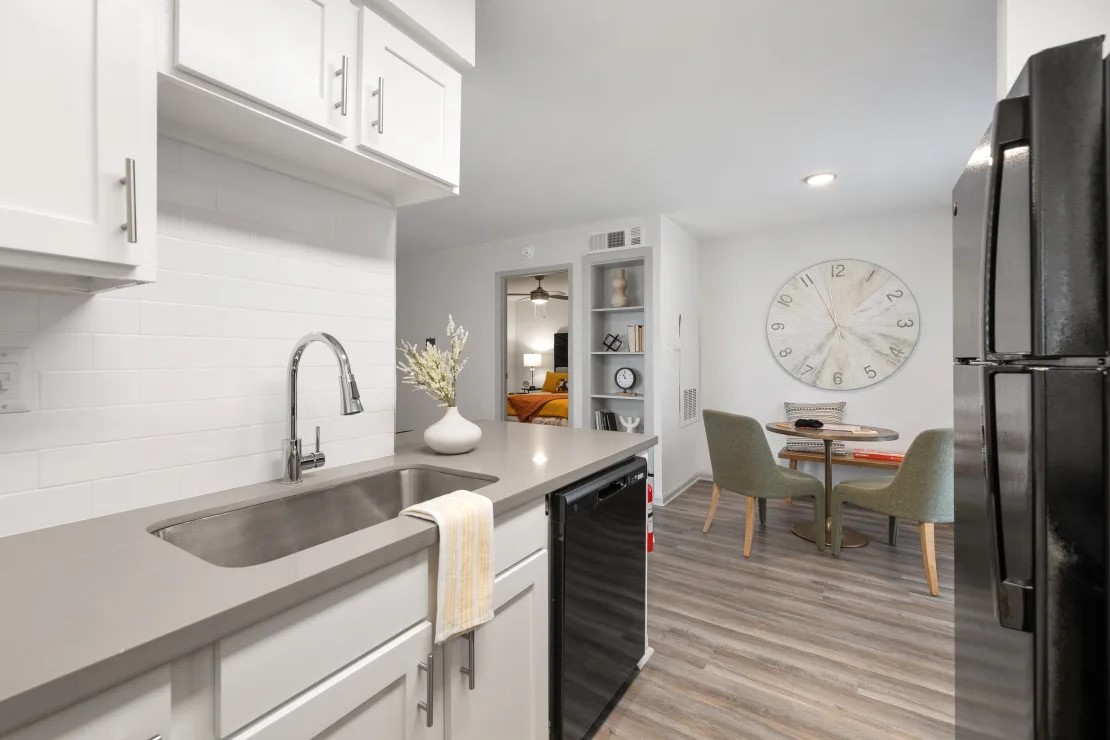 2800 South Ashford Road, Unit 1313 Houston, TX 77082 - Photo 17 of 20 a kitchen with stainless steel appliances granite countertop a table chairs in it and wooden floors