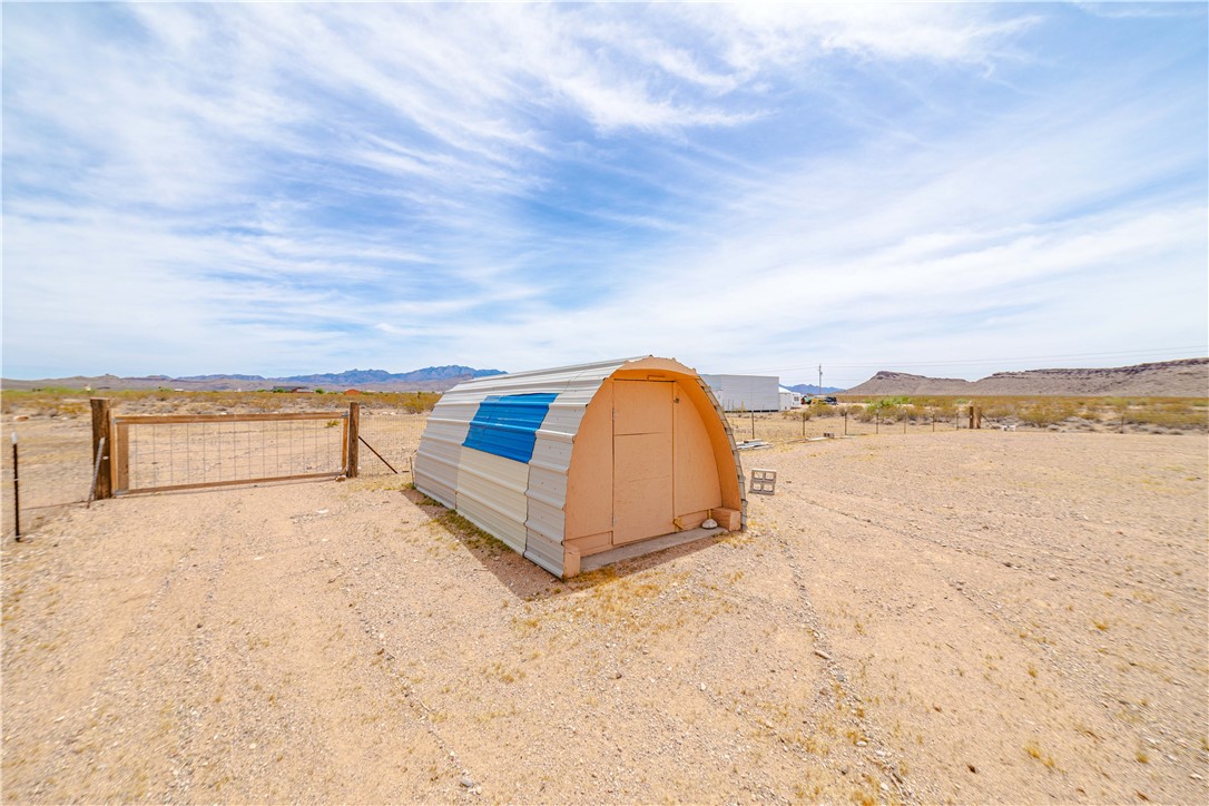 2948 Pinal Road Golden Valley, AZ 86413 - Photo 45 of 59 Quonset hut structure with a corrugated metal exterior, featuring a blue accent panel