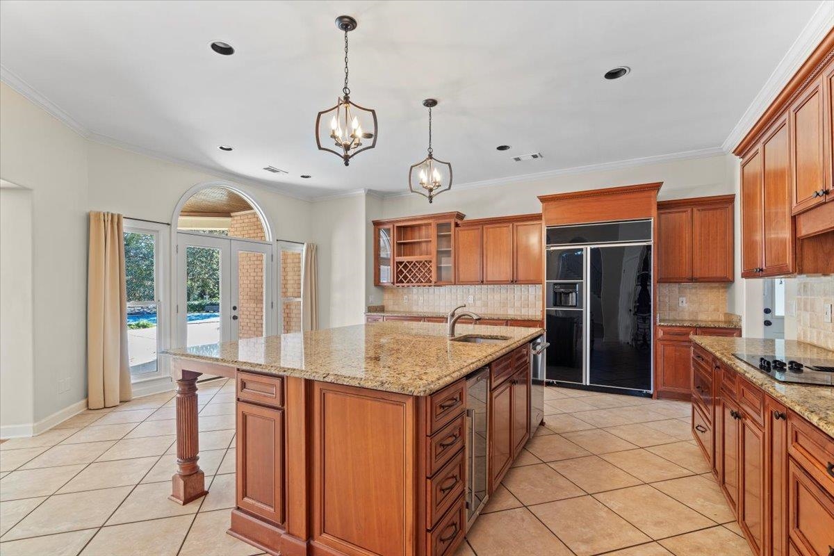 170 Jamerson Farm Road Collierville, TN 38017 - Photo 13 of 40 Kitchen featuring crown molding, black electric cooktop, an island with sink, and built in refrigerator
