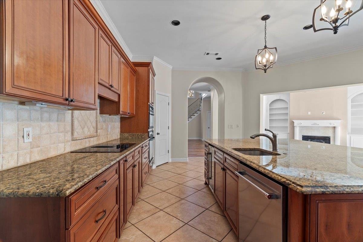 170 Jamerson Farm Road Collierville, TN 38017 - Photo 15 of 40 Kitchen featuring sink, light stone counters, pendant lighting, a kitchen island with sink, and appliances with stainless steel finishes