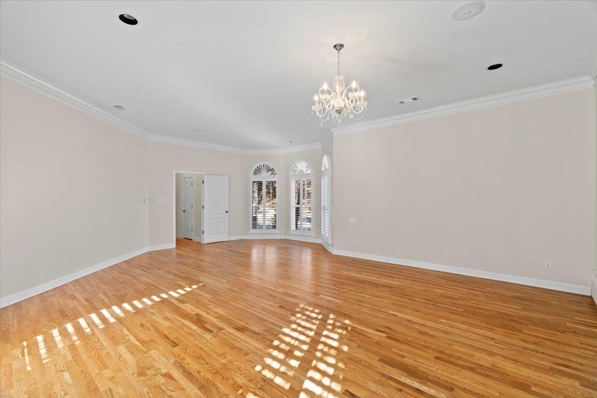 170 Jamerson Farm Road Collierville, TN 38017 - Photo 19 of 40 Unfurnished living room featuring a notable chandelier, light wood-type flooring, and ornamental molding