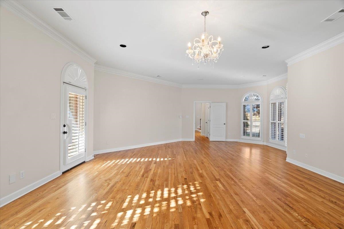 170 Jamerson Farm Road Collierville, TN 38017 - Photo 20 of 40 Spare room with a chandelier, a healthy amount of sunlight, ornamental molding, and light hardwood / wood-style flooring