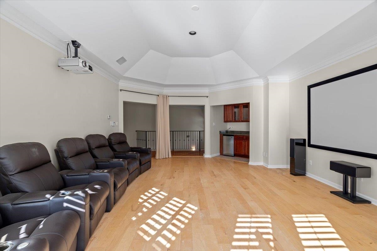 170 Jamerson Farm Road Collierville, TN 38017 - Photo 29 of 40 Home theater room featuring ornamental molding, vaulted ceiling, and light wood-type flooring