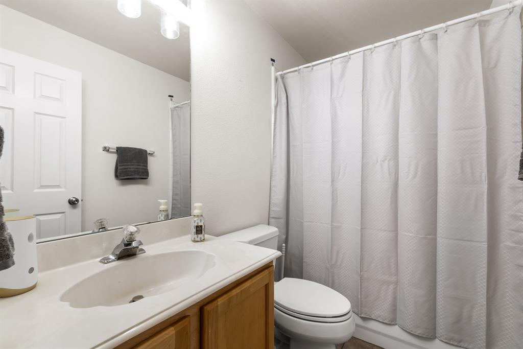 10903 Robincreek Lane Frisco, TX 75035 - Photo 13 of 17 a bathroom with a sink a toilet and shower curtain