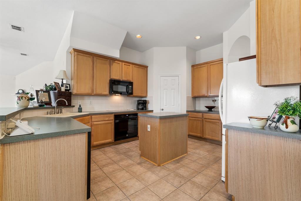 10903 Robincreek Lane Frisco, TX 75035 - Photo 6 of 17 a kitchen with a sink stove and microwave
