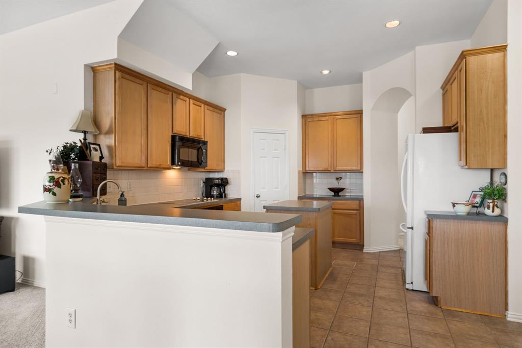 10903 Robincreek Lane Frisco, TX 75035 - Photo 7 of 17 a kitchen with a sink a stove and cabinets