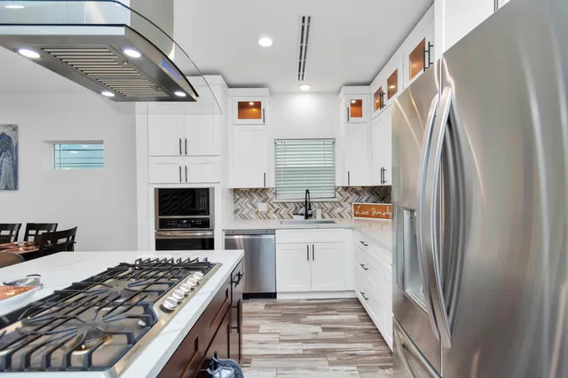 a kitchen with white cabinets and appliances