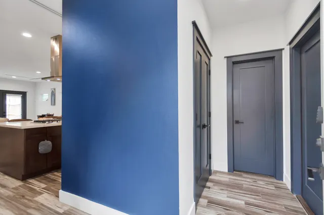 a view of a hallway with wooden floor and staircase