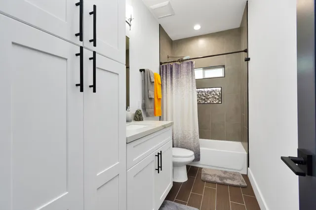 a bathroom with a shower a sink and a toilet