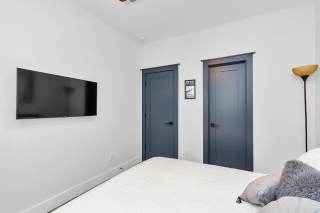 a bedroom with a bed and a flat screen tv