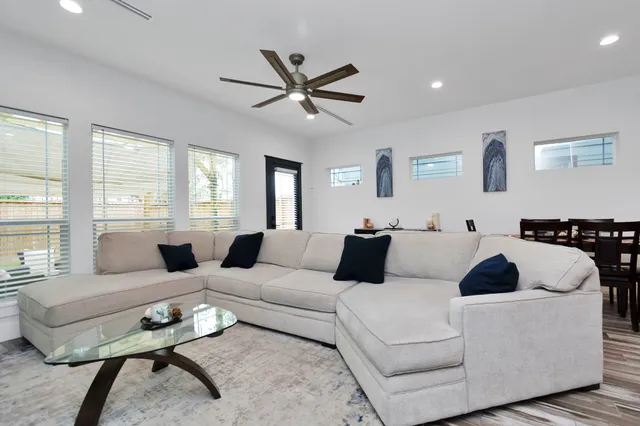 a living room with furniture ceiling fan and a window