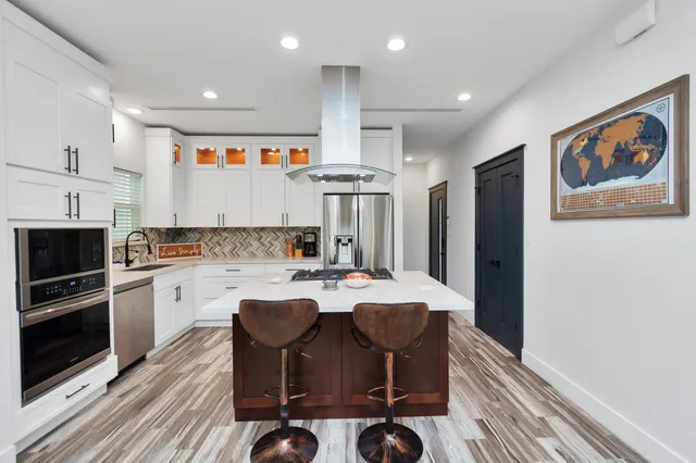 a kitchen with granite countertop cabinets a stove a dining table and chairs