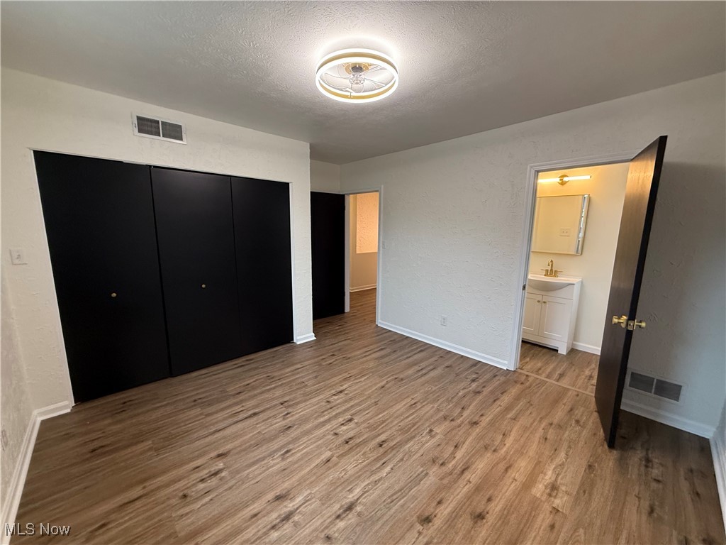 522 North 3rd Street Toronto, OH 43964 - Photo 28 of 47 Unfurnished bedroom featuring a textured ceiling, light wood-style flooring, a textured wall, and a closet