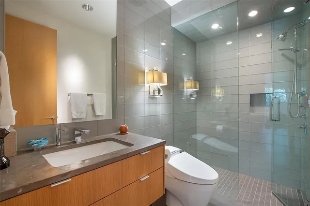 a bathroom with a granite countertop sink toilet and shower
