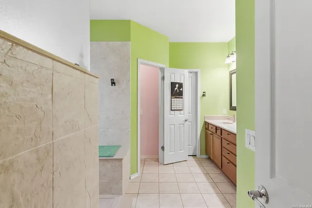 a bathroom with a granite countertop shower and a sink