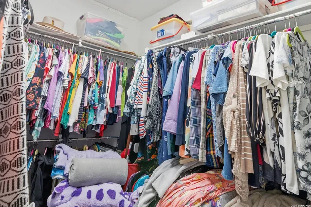 a view of walk in closet with clothes and shoes