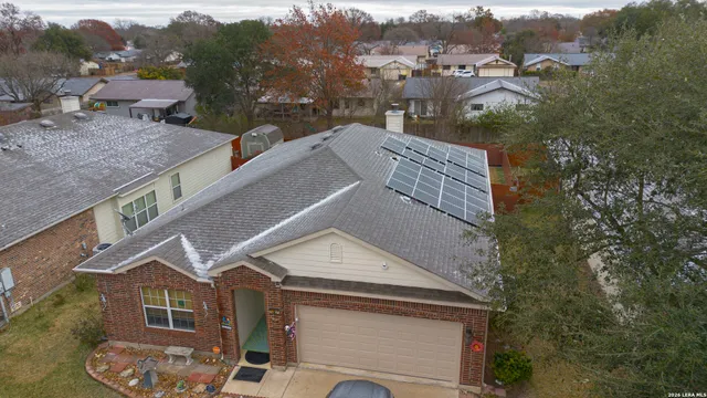 a aerial view of a house with a yard and balcony