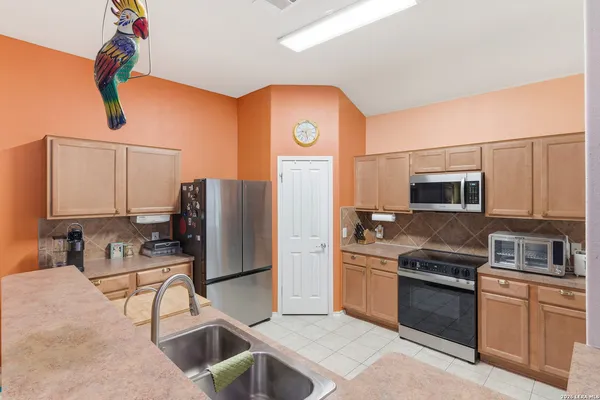 a kitchen with stainless steel appliances granite countertop a refrigerator and a stove top oven