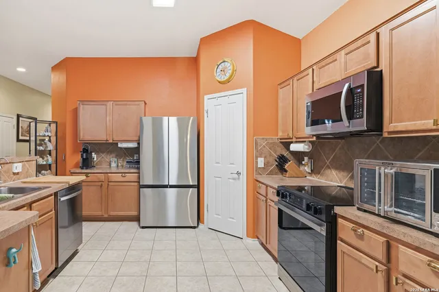 a kitchen with stainless steel appliances granite countertop a refrigerator stove and sink