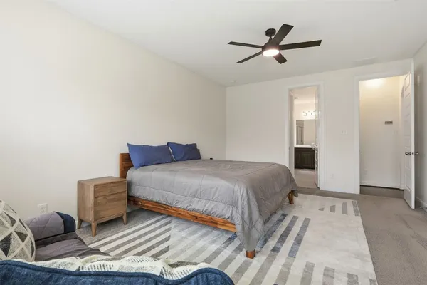 a bedroom with a bed and a ceiling fan