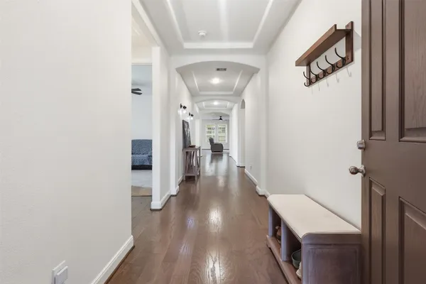 a view of a hallway with wooden floor and staircase