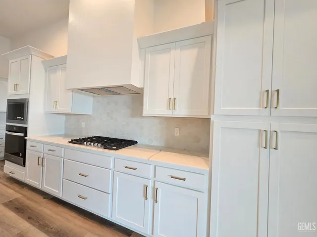 a kitchen with white cabinets and white appliances