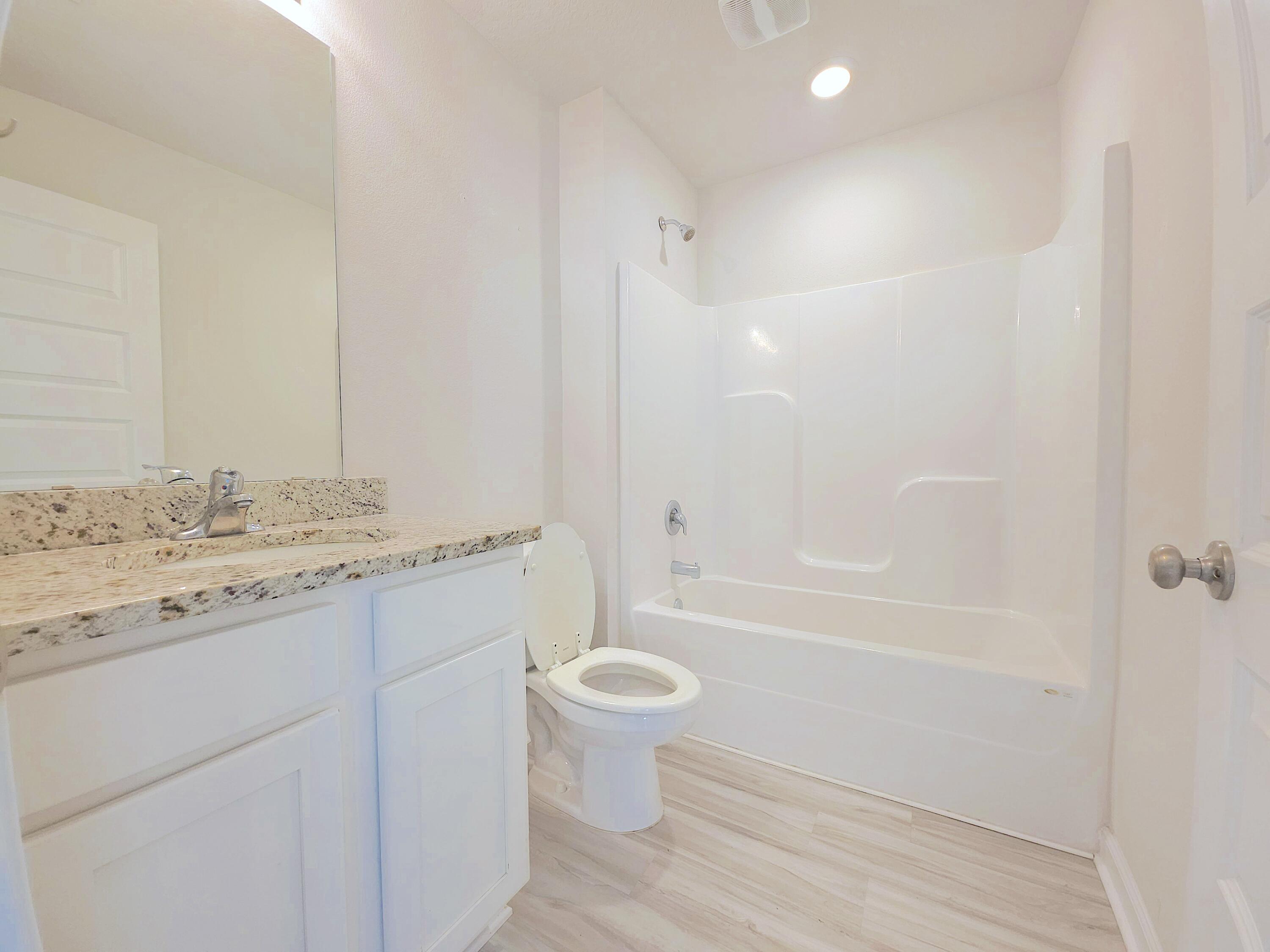 805 Otto Loop Crestview, FL 32539 - Photo 15 of 32 a bathroom with a granite countertop sink a toilet and shower