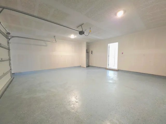 an empty room with a ceiling fan and windows