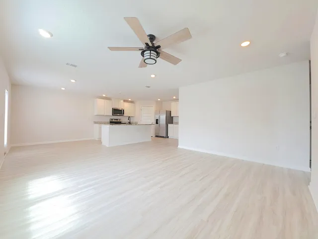 a view of a kitchen with a sink and dishwasher a refrigerator with wooden floor