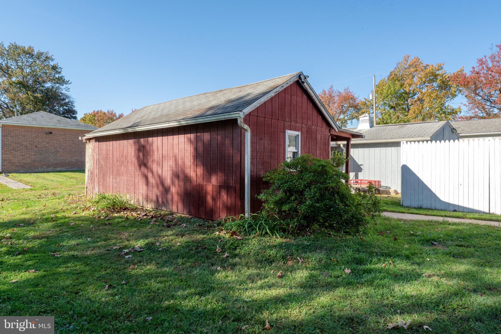 28 Harding Street Manchester, PA 17345 - Photo 34 of 44 Charming red shed nestled in green grass.
