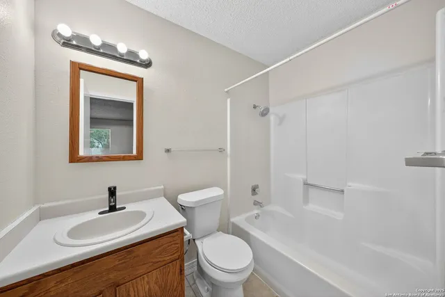 a bath room with a toilet a sink and a mirror