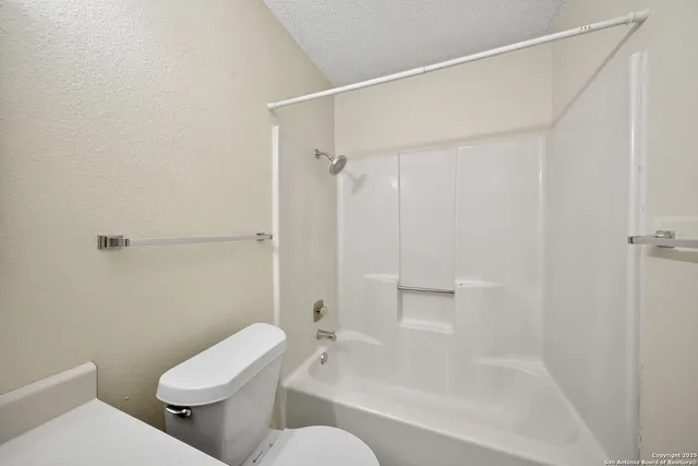 a white toilet sitting next to a bath tub