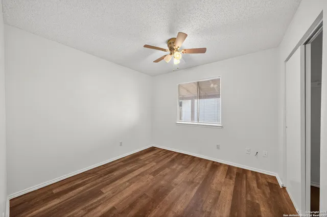 a view of a room with wooden floor and ceiling fan