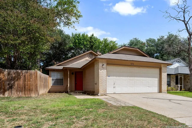 a front view of a house with a garden and trees