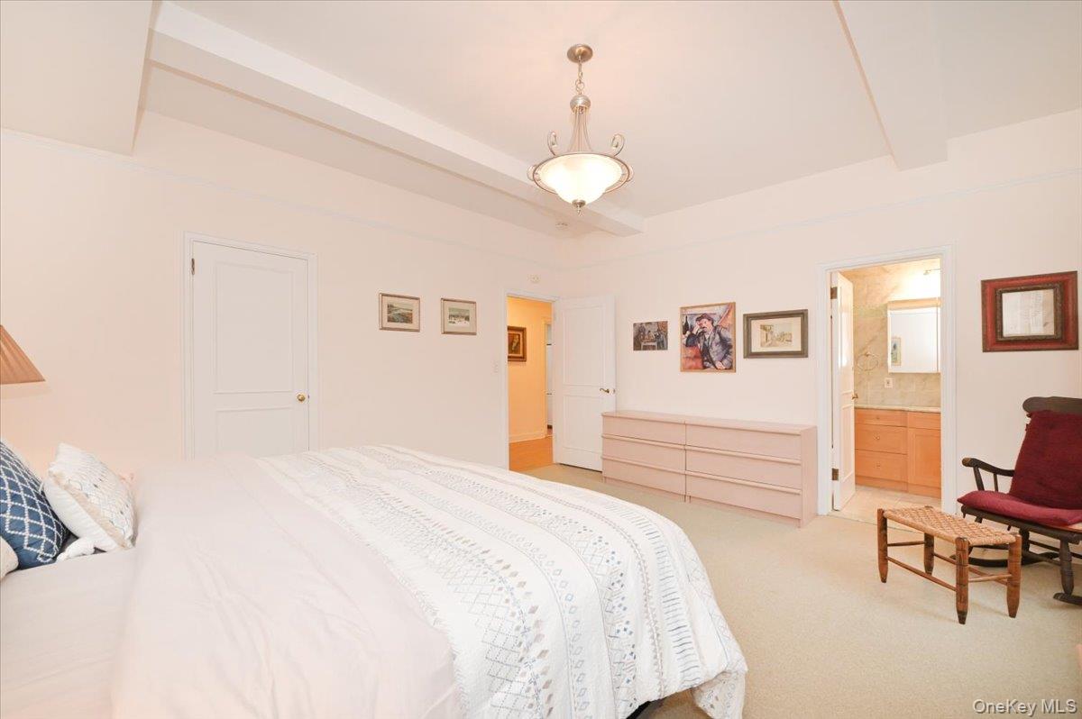 160 Middle Neck Road, Unit 2G Great Neck, NY 11021 - Photo 27 of 41 a bedroom with a bed and a chandelier