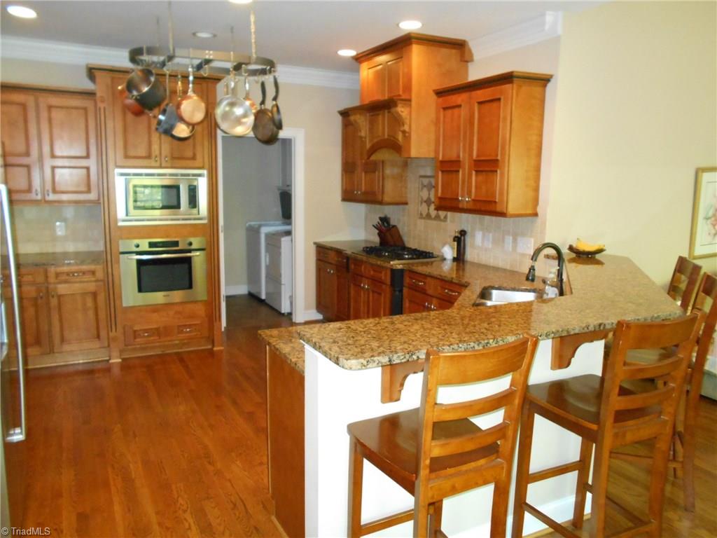 5044 Bennington Way High Point, NC 27262 - Photo 5 of 28 Kitchen with with pot rack, granite counters, stainless Bosch appliances & gas down-draft cooktop