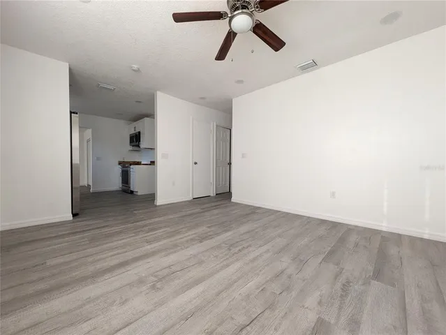 a view of a room with wooden floor and white walls