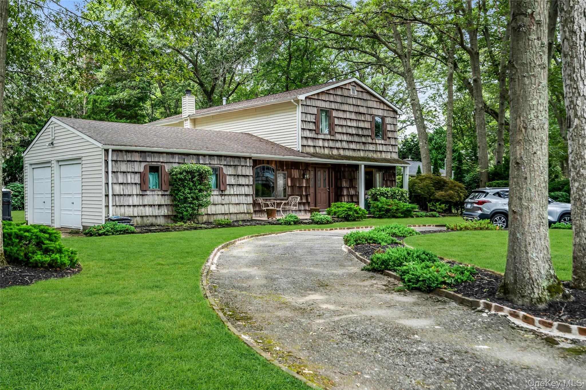 58 Rhoda Avenue Smithtown, NY 11787 - Photo 1 of 1 View of front of house with a shingled roof, a front lawn, a chimney, and driveway