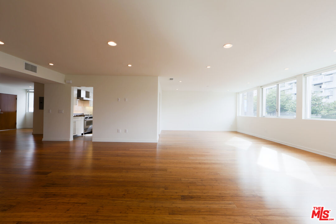 10366 Wilshire Boulevard, Unit 201 Los Angeles, CA 90024 - Photo 2 of 7 a view of an empty room with wooden floor and a window