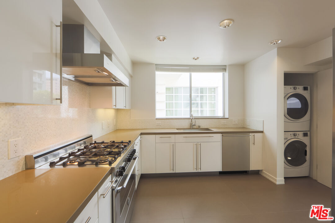 10366 Wilshire Boulevard, Unit 201 Los Angeles, CA 90024 - Photo 3 of 7 a kitchen with stainless steel appliances granite countertop a sink and a stove