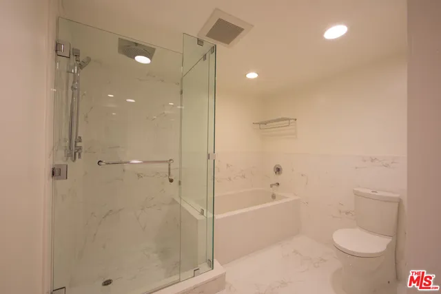a bathroom with a shower a toilet and a shower