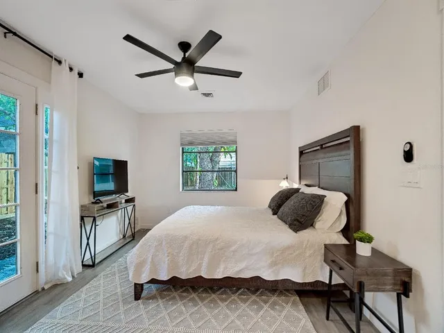 a bedroom with a bed and a flat tv screen on the dresser