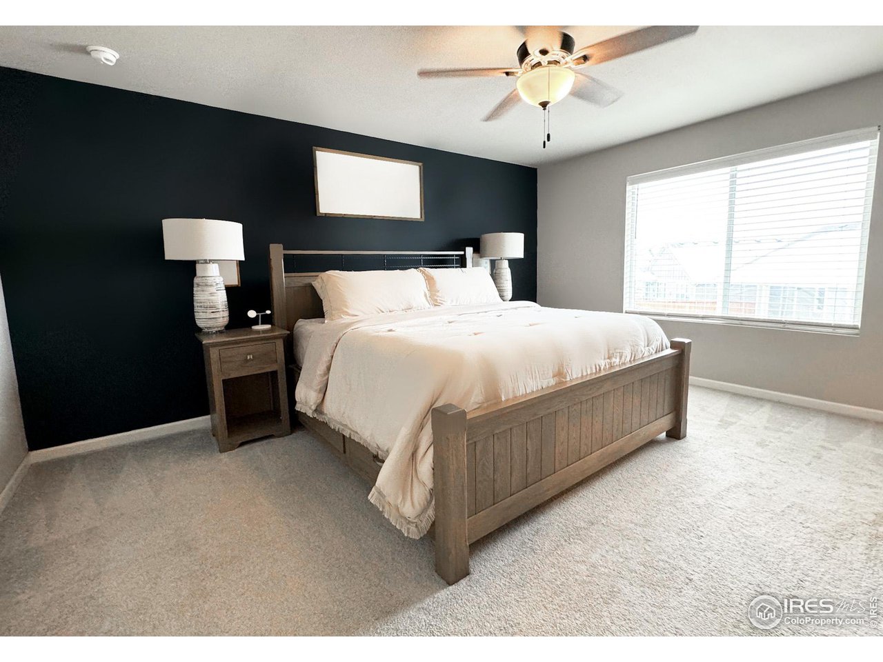 531 Ranchhand Drive Berthoud, CO 80513 - Photo 13 of 34 a bedroom with a bed and a chandelier