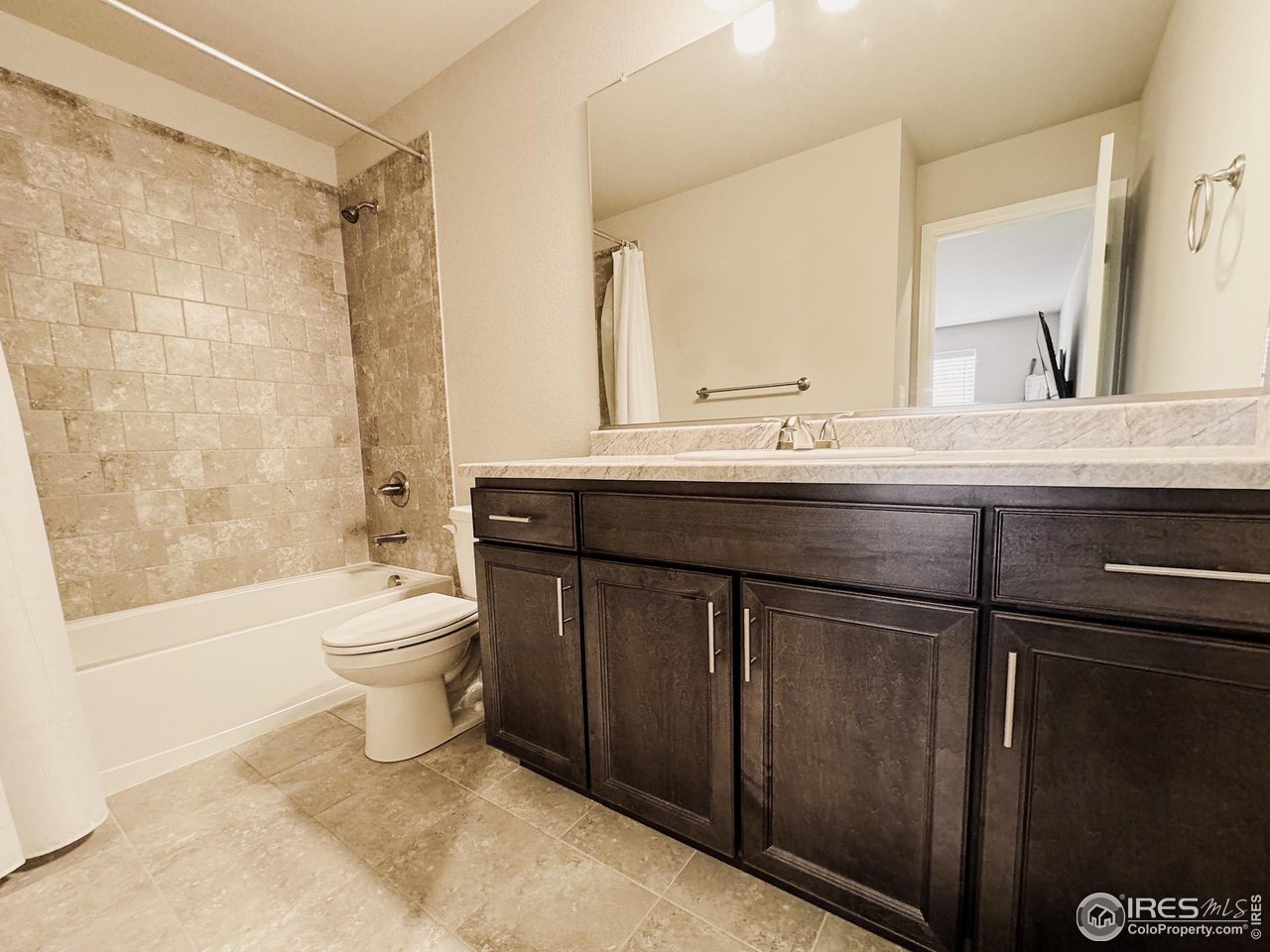 531 Ranchhand Drive Berthoud, CO 80513 - Photo 18 of 34 a bathroom with a sink a toilet a mirror and shower