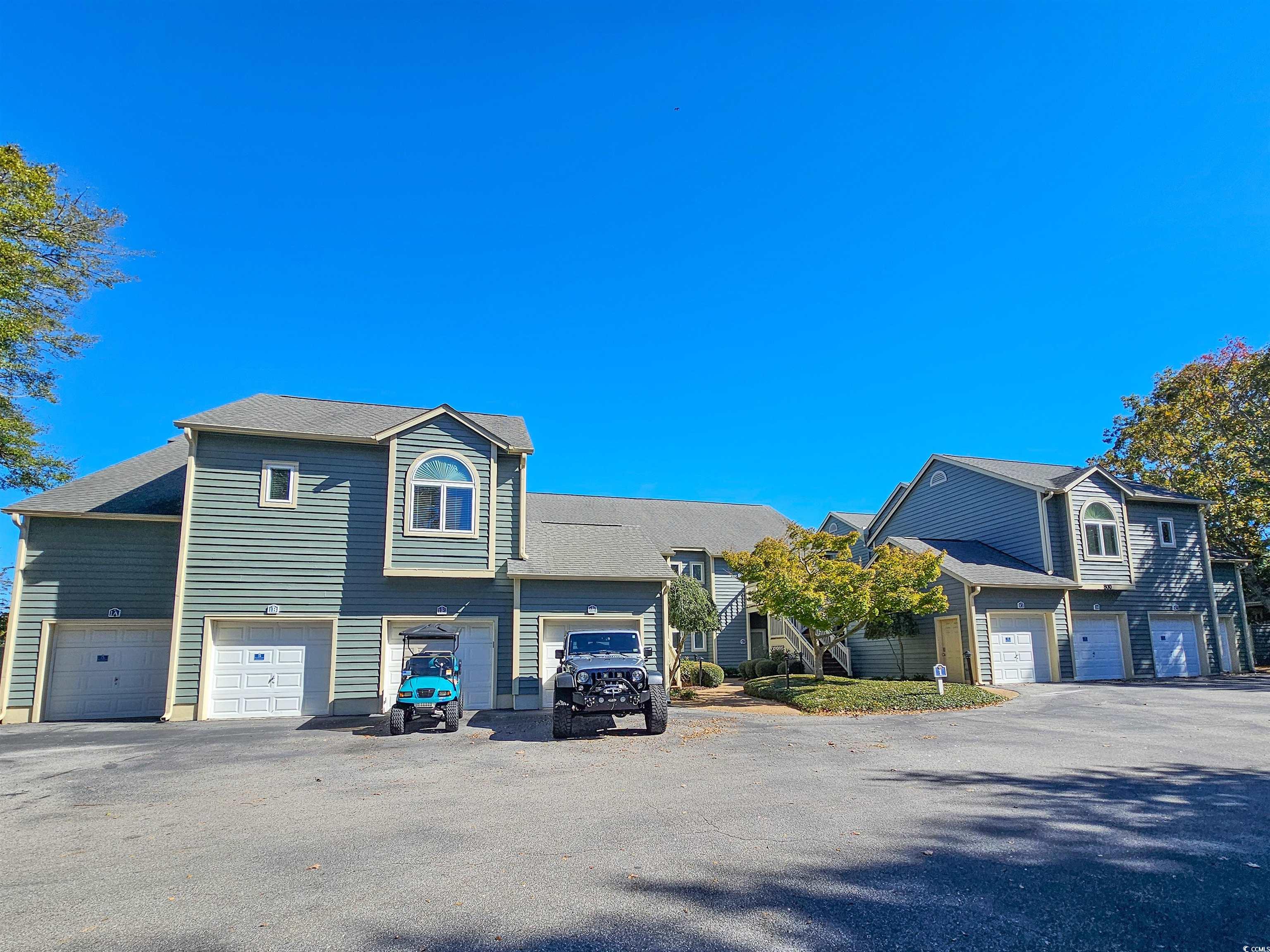 View of front of property with asphalt driveway and a garage