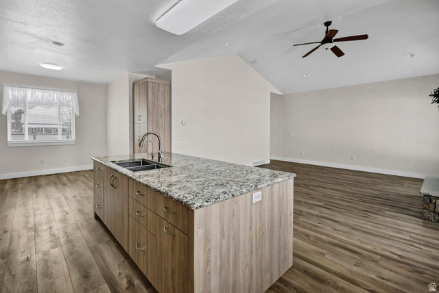 1103 North Brooklyn Road Monroe, UT 84754 - Photo 77 of 78 Kitchen featuring light stone countertops, open floor plan, an island with sink, ceiling fan, and dark wood-type flooring