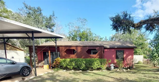 a view of a house with a yard and potted plants